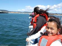 Smiling little girl on a boat, wearing a life jacket