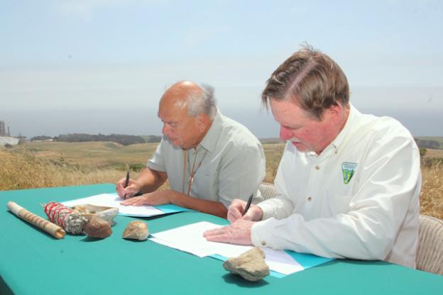 Lopez and Cooper sign the MOU.