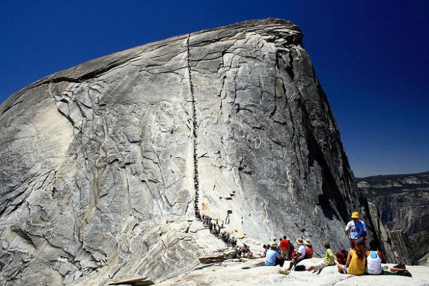 People lined up to climb the last 400 feet of Half Dome. Photo by HylgeriaK on Creative Commons.