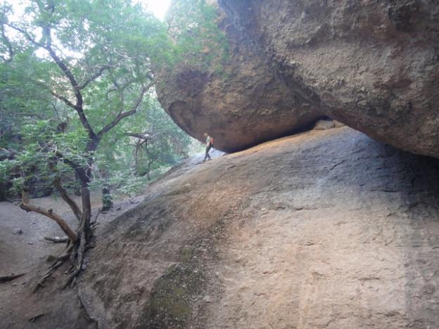 A person dwarfed by a rock formation at Pinnacles National Park. Photo credit: Garrett McAuliffe.