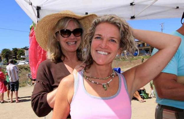 Heidi Nilson trying on her new necklace with the help of Kathy Julian.