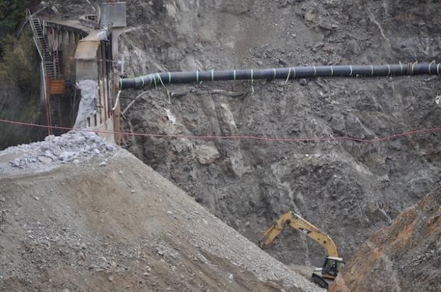 The river flows through a feeding tube lashed to the hillside as the San Clemente Dam is removed.