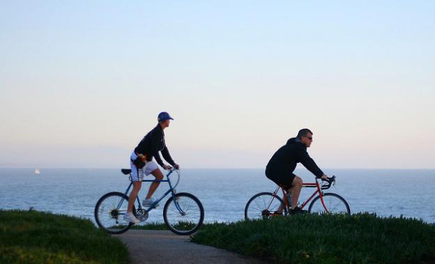 These West Cliff Drive riders will be able to pedal all the way to Coast Dairies soon (hopefully). Photo by Richard Masoner/CC.