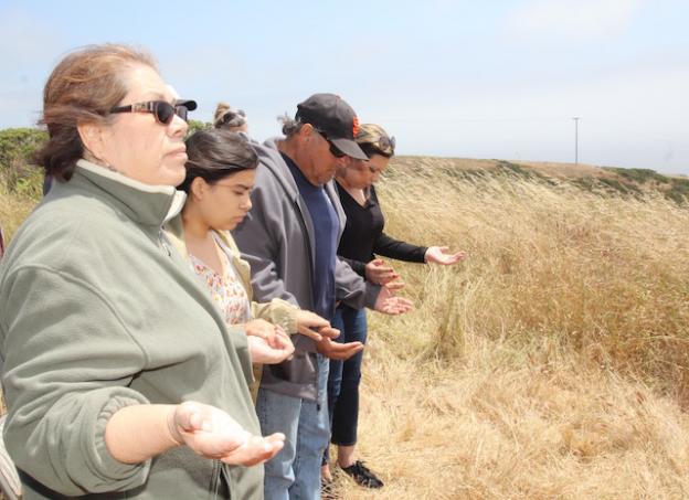 Tribal Treasurer Denise Espinosa, left, prays with other Amah Mutsun members.