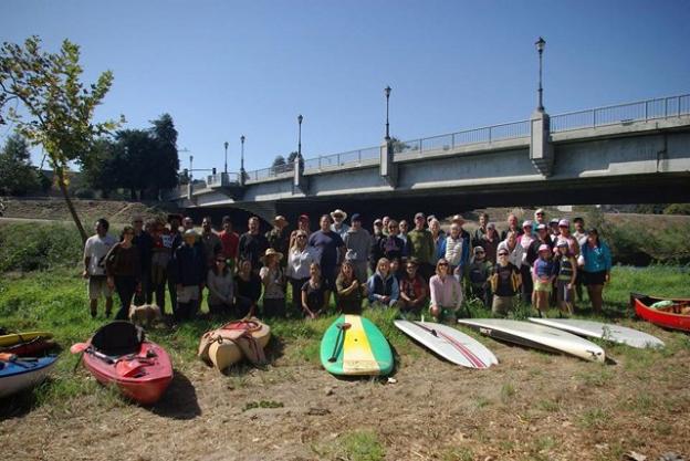 Just before launch near the Water Street Bridge, the crew poses with their watercraft. Photo by Melissa Foley.