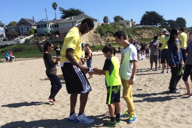 After the heavy lifting comes the care and feeding of fans. A Warriors player signs autographs at the March 15 Seabright beach cleanup. Photo by Alexa Lomberg.