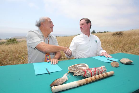 Amah Mutsun Tribal Chairman Val Lopez, left, and Rick Cooper of BLM shake hands after signing the MOU.
