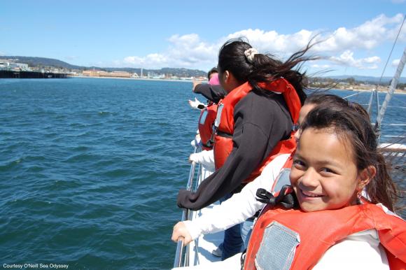 Smiling little girl on a boat, wearing a life jacket