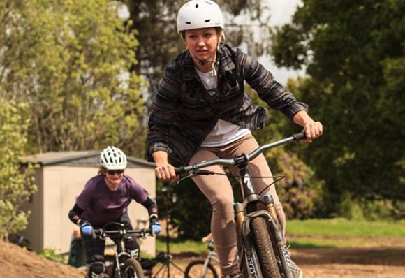 Brittany Bolen (front) and Jennifer Joy round the bend at the March pump track session with Shine. Photo by Clay Ryon.