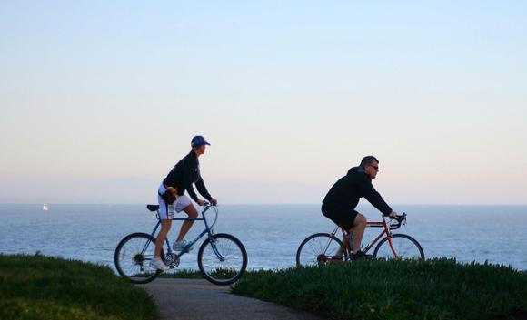 These West Cliff Drive riders will be able to pedal all the way to Coast Dairies soon (hopefully). Photo by Richard Masoner/CC.