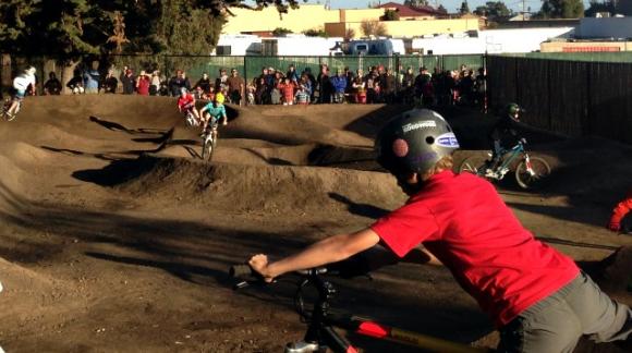 Bike groms lined up to take a turn on the new Westside pump track at the official ribbon-cutting on Saturday. Hanae Armitage photo.